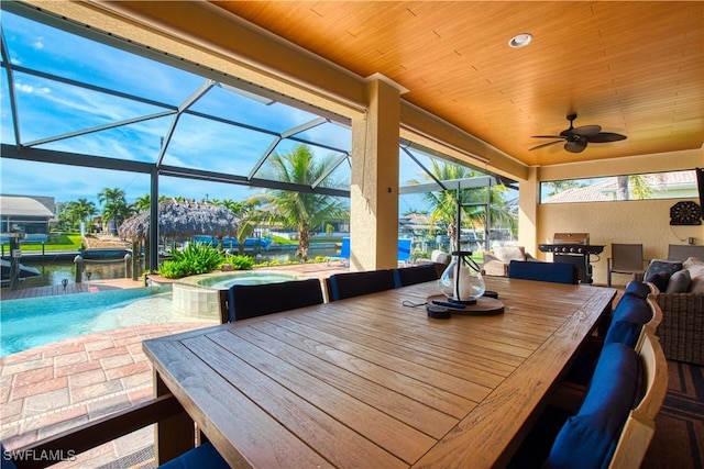 view of patio / terrace with a lanai, ceiling fan, a pool with connected hot tub, and outdoor dining area