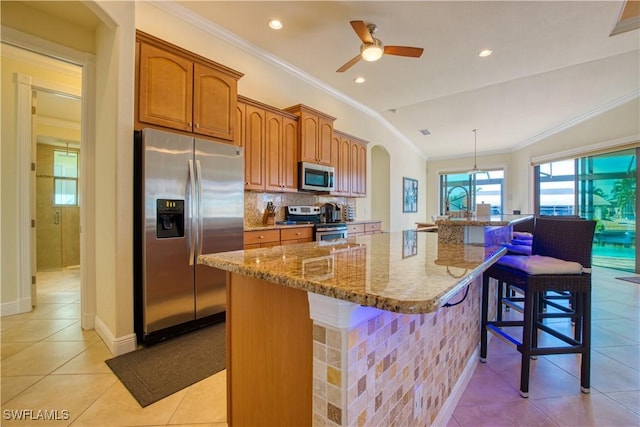 kitchen with arched walkways, tasteful backsplash, appliances with stainless steel finishes, and crown molding