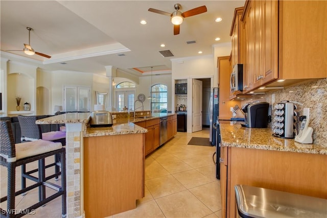 kitchen with appliances with stainless steel finishes, tasteful backsplash, a breakfast bar area, and a ceiling fan