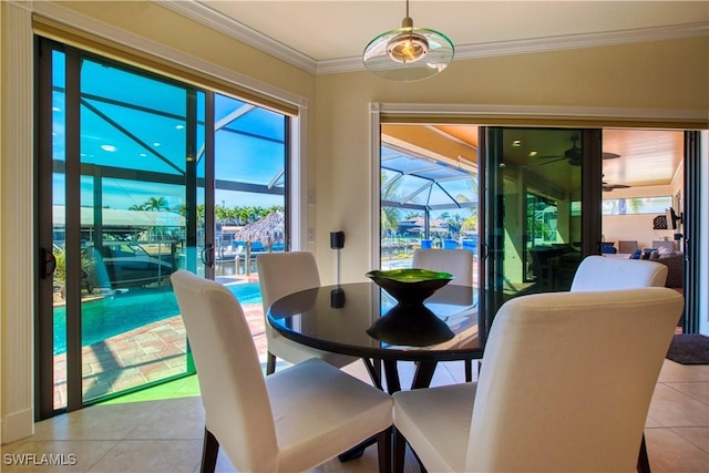 dining room with a sunroom, crown molding, and light tile patterned flooring