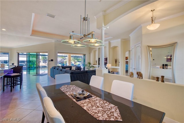 dining area featuring arched walkways, light tile patterned flooring, visible vents, ornate columns, and crown molding