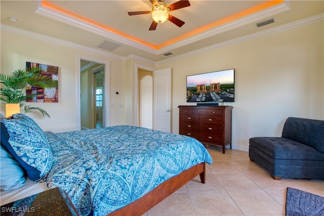 bedroom with light tile patterned floors, visible vents, a tray ceiling, and crown molding