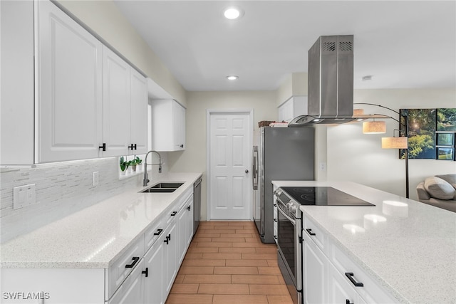 kitchen with appliances with stainless steel finishes, a sink, white cabinets, and island range hood