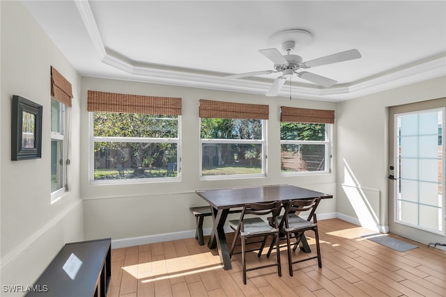 sunroom featuring a tray ceiling and a ceiling fan