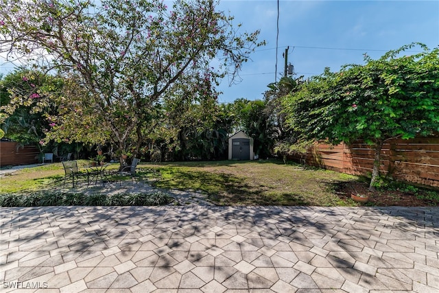 view of patio / terrace with a storage shed, an outbuilding, and a fenced backyard