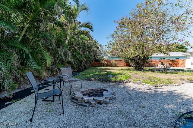 view of yard featuring a patio area, fence, and a fire pit