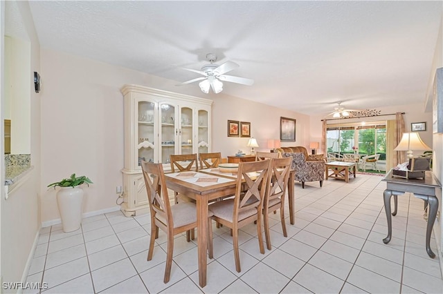 dining room featuring ceiling fan, baseboards, and light tile patterned floors