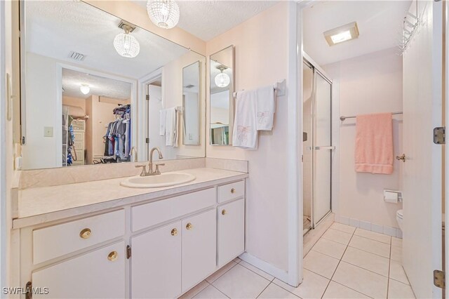 full bath with tile patterned flooring, toilet, visible vents, vanity, and a shower stall