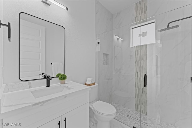 full bathroom with toilet, a marble finish shower, and vanity