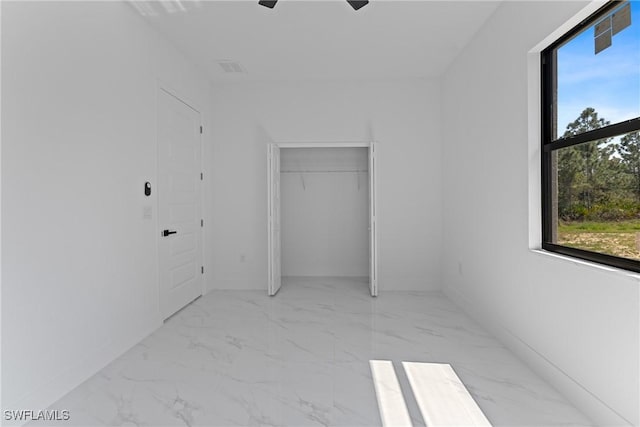 unfurnished room featuring marble finish floor and a ceiling fan