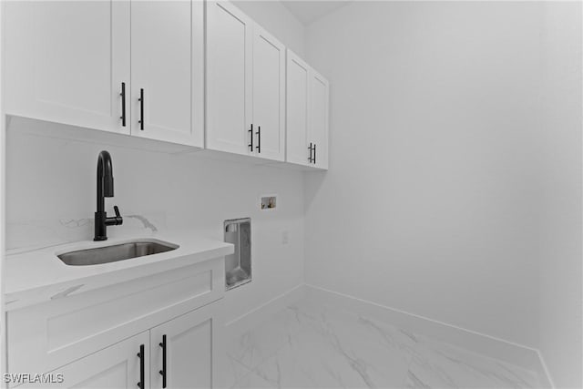 washroom with marble finish floor, hookup for a washing machine, cabinet space, a sink, and baseboards