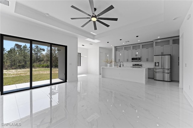 unfurnished living room featuring marble finish floor, a raised ceiling, visible vents, and recessed lighting