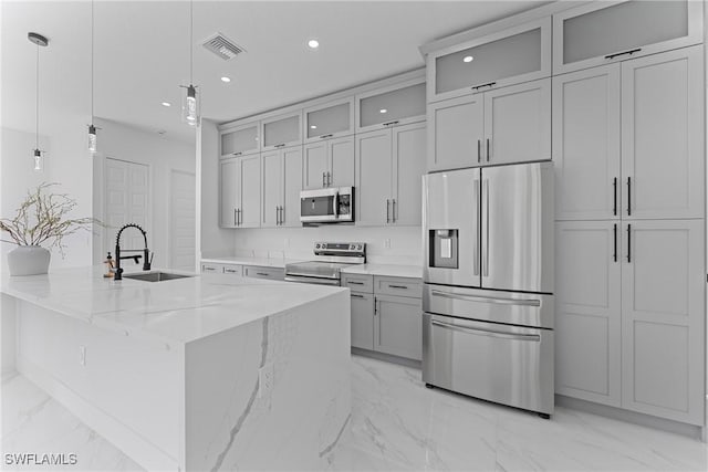 kitchen with visible vents, light stone counters, marble finish floor, stainless steel appliances, and a sink