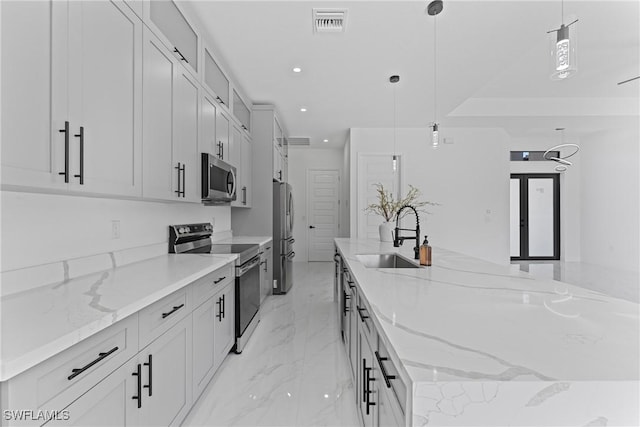 kitchen with a spacious island, a sink, visible vents, marble finish floor, and appliances with stainless steel finishes