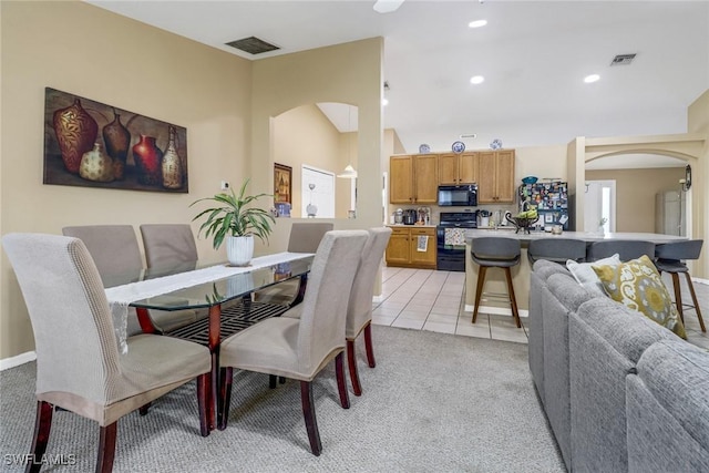 dining area featuring light tile patterned floors, visible vents, arched walkways, and recessed lighting