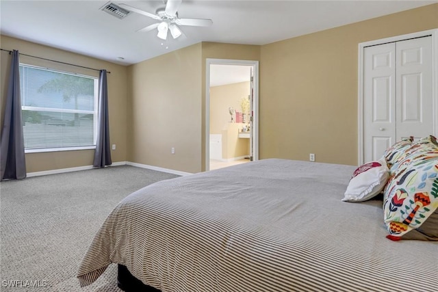 carpeted bedroom with ceiling fan, connected bathroom, visible vents, baseboards, and a closet