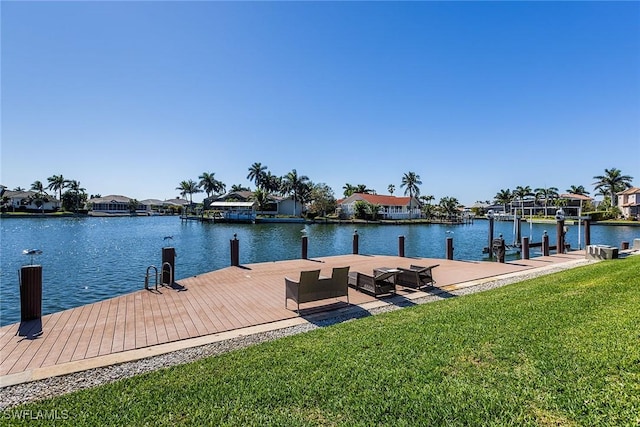 view of dock featuring a water view, a residential view, and a yard