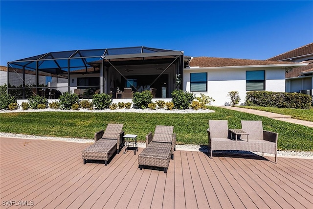 rear view of property featuring a yard, a wooden deck, glass enclosure, and stucco siding