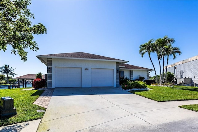 view of front of home featuring a garage, stucco siding, concrete driveway, and a front yard