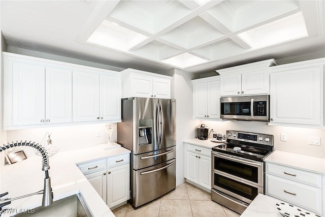 kitchen with stainless steel appliances, light countertops, a sink, and white cabinetry