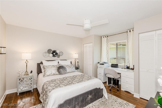 bedroom featuring a ceiling fan, baseboards, multiple closets, and wood finished floors