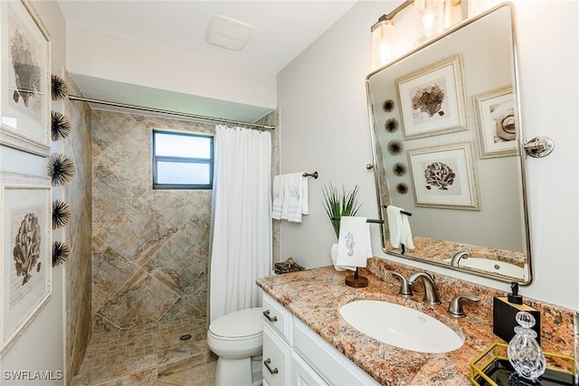 bathroom featuring toilet, tiled shower, and vanity