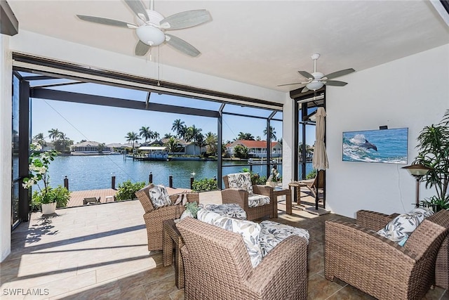 view of patio with an outdoor hangout area, glass enclosure, a water view, and a ceiling fan