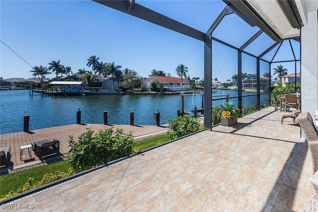 view of patio / terrace featuring glass enclosure, a boat dock, and a water view