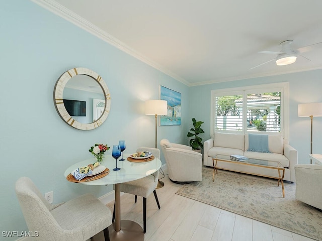 living area with light wood-style floors, a ceiling fan, and crown molding