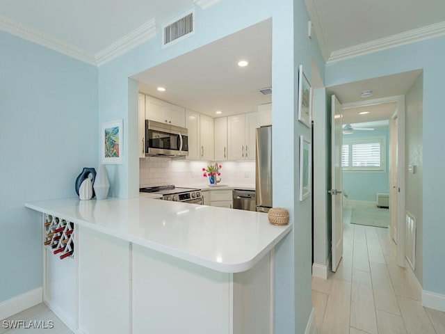 kitchen with appliances with stainless steel finishes, visible vents, ornamental molding, and backsplash