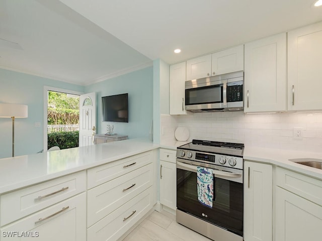 kitchen with white cabinetry, light countertops, ornamental molding, appliances with stainless steel finishes, and tasteful backsplash