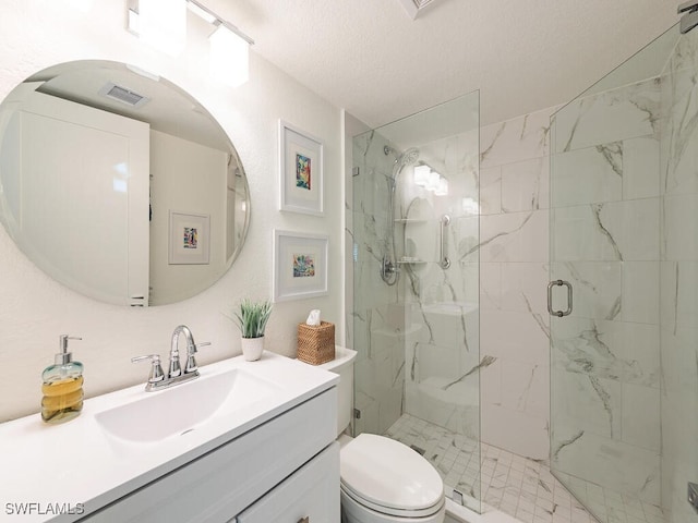 bathroom featuring toilet, a marble finish shower, a textured ceiling, and vanity