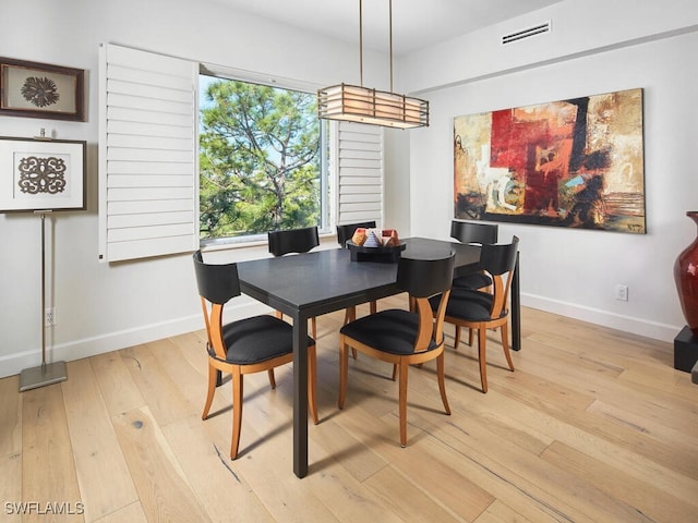 dining area featuring baseboards, visible vents, and light wood-style floors