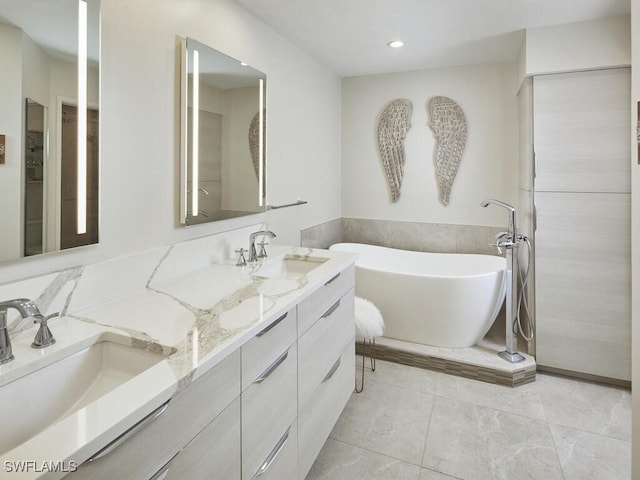 bathroom with double vanity, a freestanding tub, tile patterned flooring, and a sink