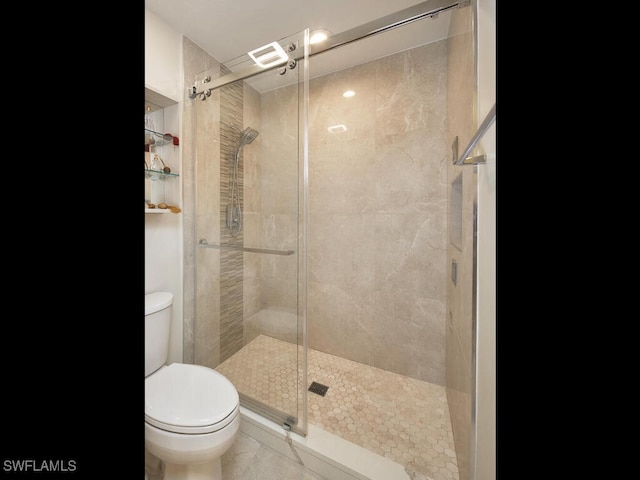 full bathroom featuring a stall shower and toilet