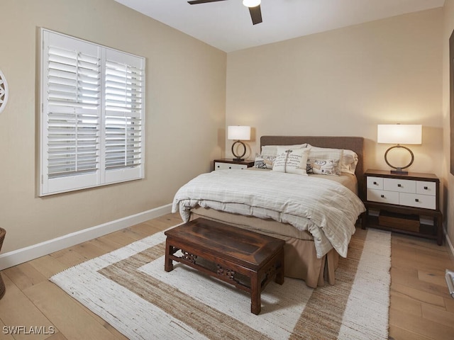 bedroom featuring ceiling fan, baseboards, and wood finished floors