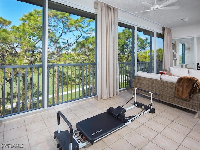 workout room with a ceiling fan and tile patterned floors