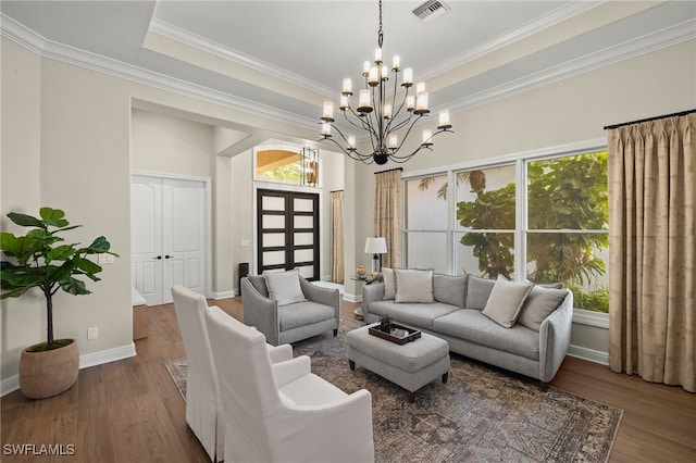 living room with visible vents, a raised ceiling, baseboards, and wood finished floors