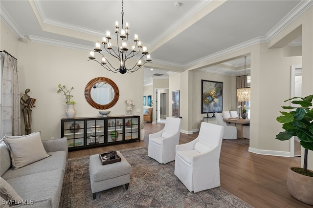 living room featuring a chandelier, baseboards, a tray ceiling, and wood finished floors