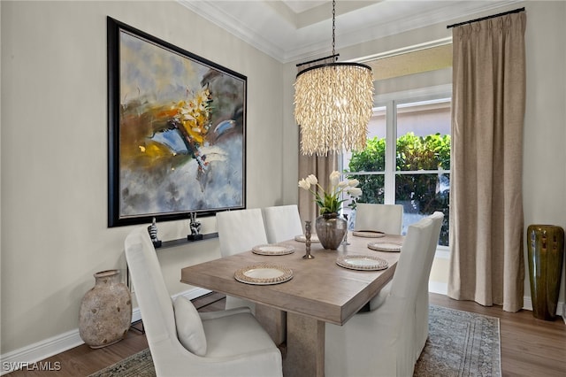 dining area with crown molding, wood finished floors, baseboards, and a chandelier