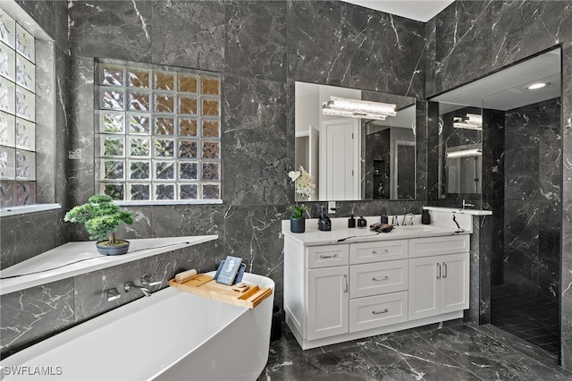 bathroom featuring tile walls, a freestanding bath, marble finish floor, and vanity