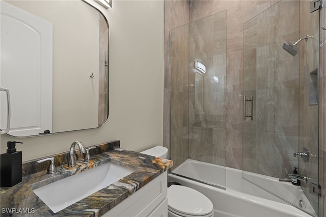 bathroom with combined bath / shower with glass door, toilet, and vanity