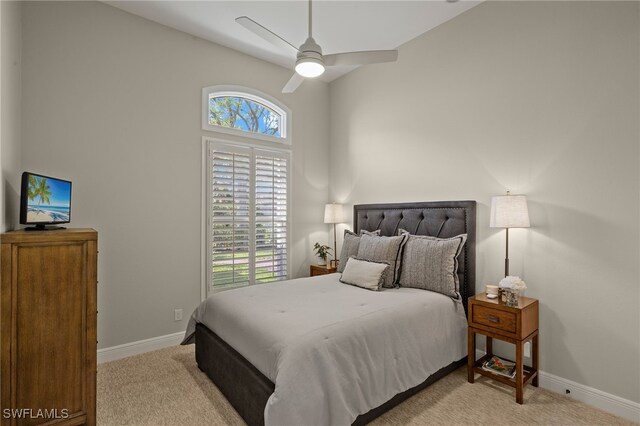 bedroom with ceiling fan, lofted ceiling, baseboards, and light carpet