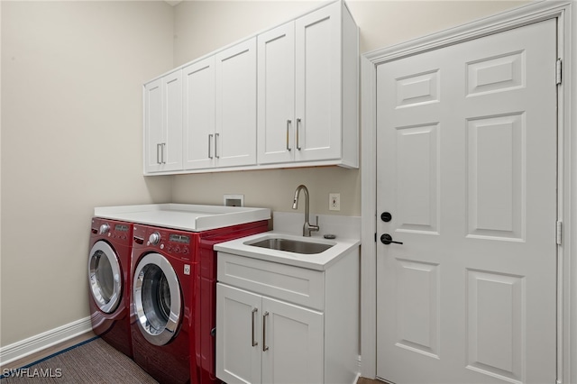 clothes washing area with separate washer and dryer, cabinet space, baseboards, and a sink