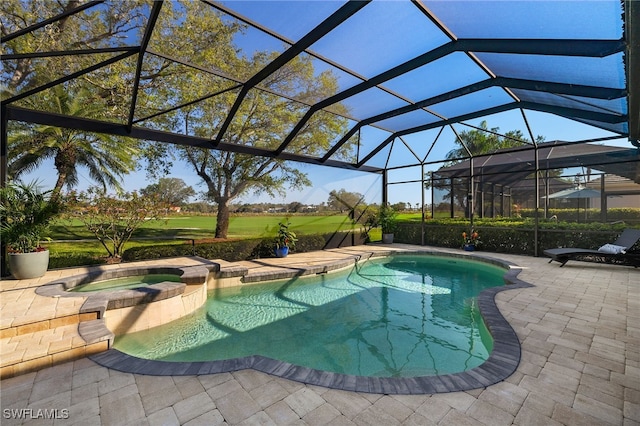 view of pool featuring a patio area, a lanai, and a pool with connected hot tub