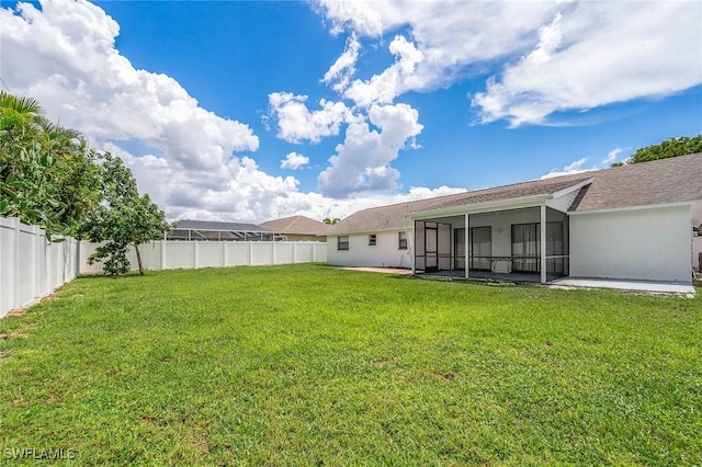 view of yard with a sunroom and a fenced backyard