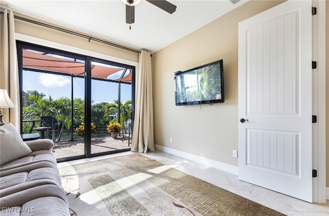 unfurnished living room with light tile patterned floors, ceiling fan, and baseboards