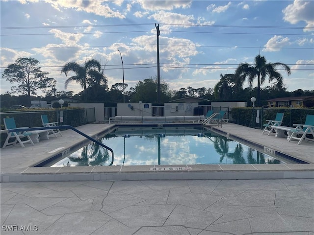 community pool featuring fence and a patio