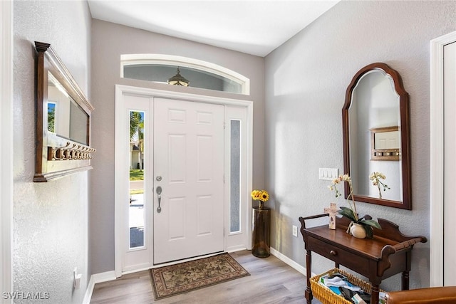 foyer entrance featuring wood finished floors and baseboards