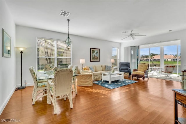 living room with baseboards, visible vents, ceiling fan, and wood finished floors